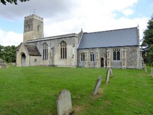 Picture of St John's Church, Little Wilbraham from the front with Green and Gravestones in the foreground.