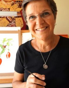 Photograph of Elaine Allison with one of her paintings in the background