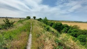 View up Fleam Dyke toward the A11 with Wadlow Wind Farm in the distance