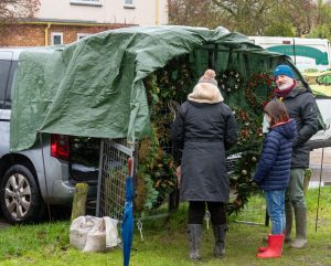 Mother and daughter shopping in the rain for a Christmas Wreath