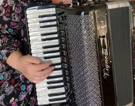 Close up image of accordion with a hand