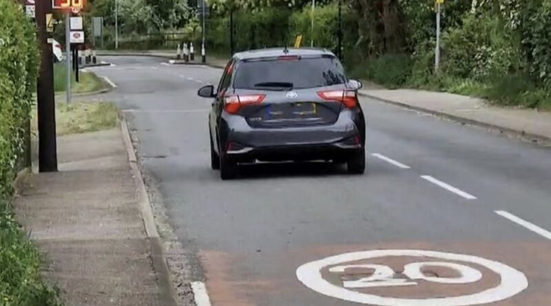 Photo of rear of car approaching the road narrowing outside the GW School and showing a 20mph road marking and an MVAS panel registering 36mph